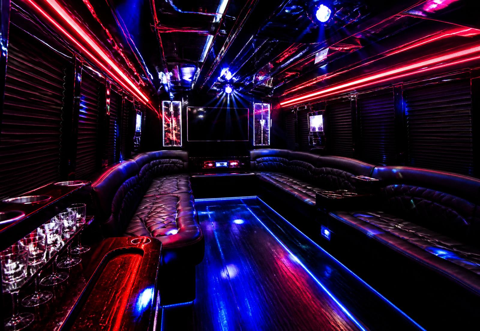 Interior of the party wagon with black leather perimeter seating and red and blue LED lighting
